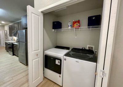 laundry closet with washer and dryer hooked up inside of an apartment at liv+ gainesville